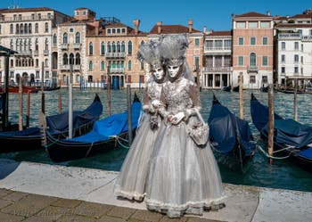 People in costume at the Venice carnival in front of the Madonna della Salute.