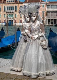 People in costume at the Venice carnival in front of the Madonna della Salute.