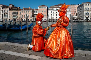 People in costume at the Venice carnival in front of the Madonna della Salute.