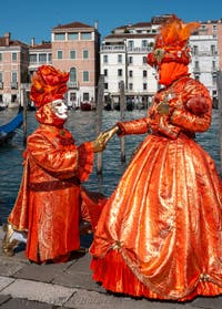 People in costume at the Venice carnival in front of the Madonna della Salute.