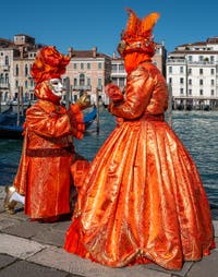 People in costume at the Venice carnival in front of the Madonna della Salute.