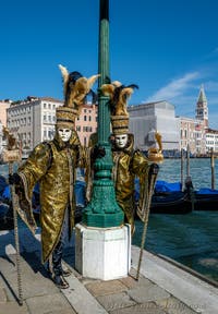 People in costume at the Venice carnival in front of the Madonna della Salute.