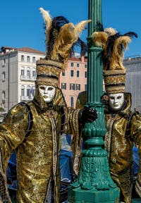 People in costume at the Venice carnival in front of the Madonna della Salute.