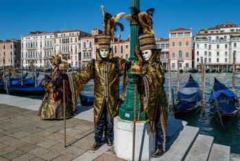 People in costume at the Venice carnival in front of the Madonna della Salute.