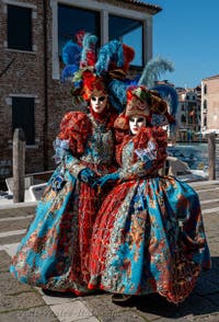 People in costume at the Venice carnival in front of the Madonna della Salute.