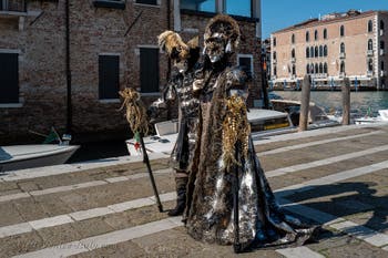 People in costume at the Venice carnival in front of the Madonna della Salute.