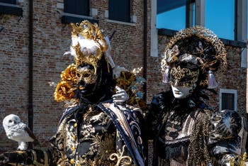 People in costume at the Venice carnival in front of the Madonna della Salute.