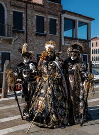 People in costume at the Venice carnival in front of the Madonna della Salute.