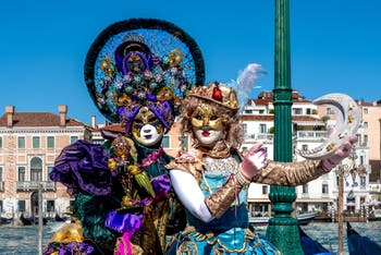 People in costume at the Venice carnival in front of the Madonna della Salute.