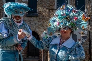 People in costume at the Venice carnival in front of the Madonna della Salute.