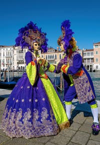 People in costume at the Venice carnival in front of the Madonna della Salute.