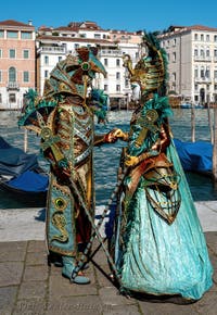 People in costume at the Venice carnival in front of the Madonna della Salute.